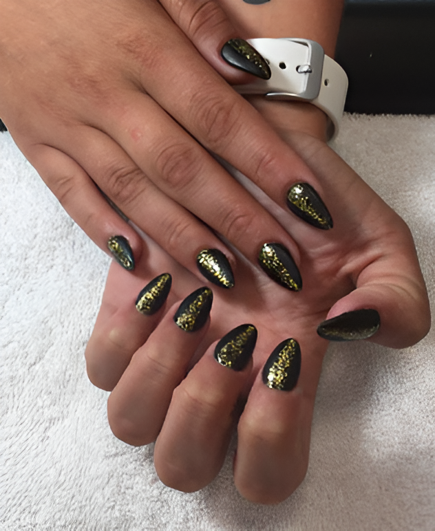 Elegant black stiletto nails with gold glitter accents